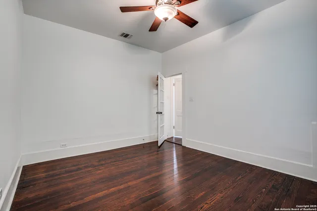 a view of room with hardwood floor and ceiling fan