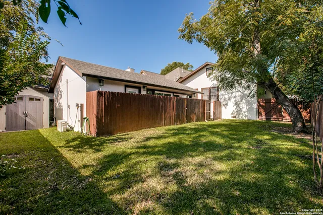 a view of backyard of house with green space