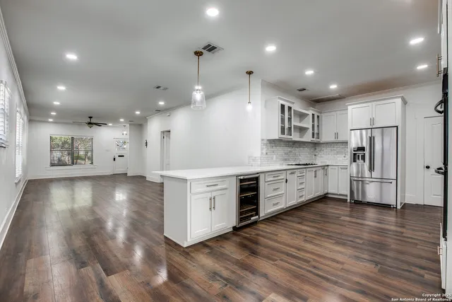 a large kitchen with stainless steel appliances granite countertop a large counter top a sink and a stove