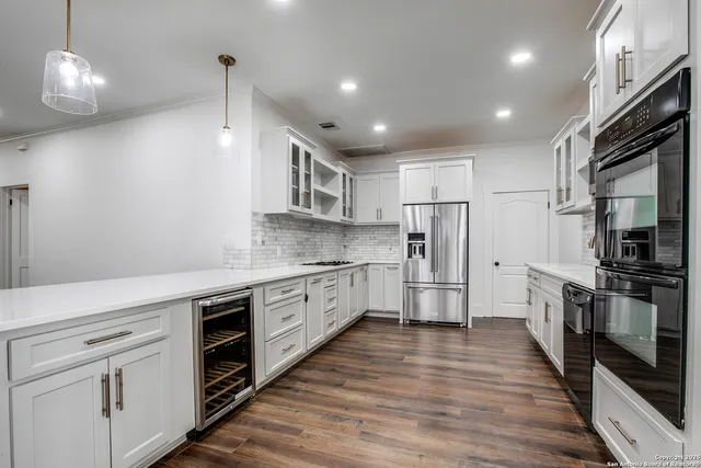 a large kitchen with stainless steel appliances granite countertop a stove a sink and a refrigerator