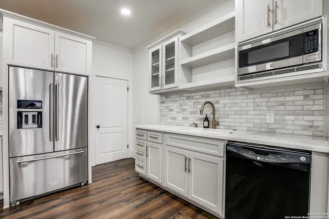 a kitchen with stainless steel appliances a refrigerator sink and microwave