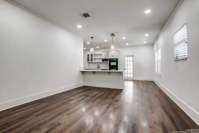 a view of kitchen with kitchen island microwave and wooden floor
