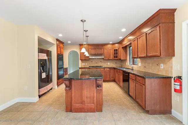 a kitchen with stainless steel appliances granite countertop a refrigerator a sink and a stove