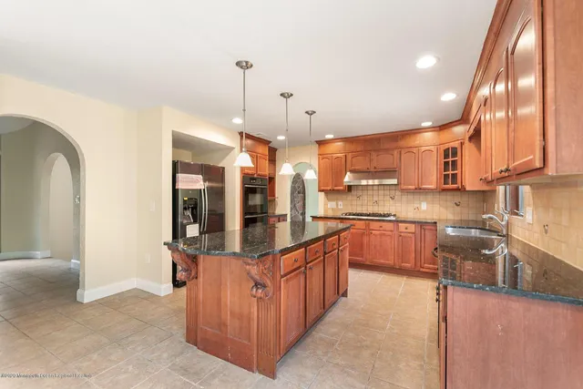 a kitchen with stainless steel appliances granite countertop a stove a sink and a wooden floors