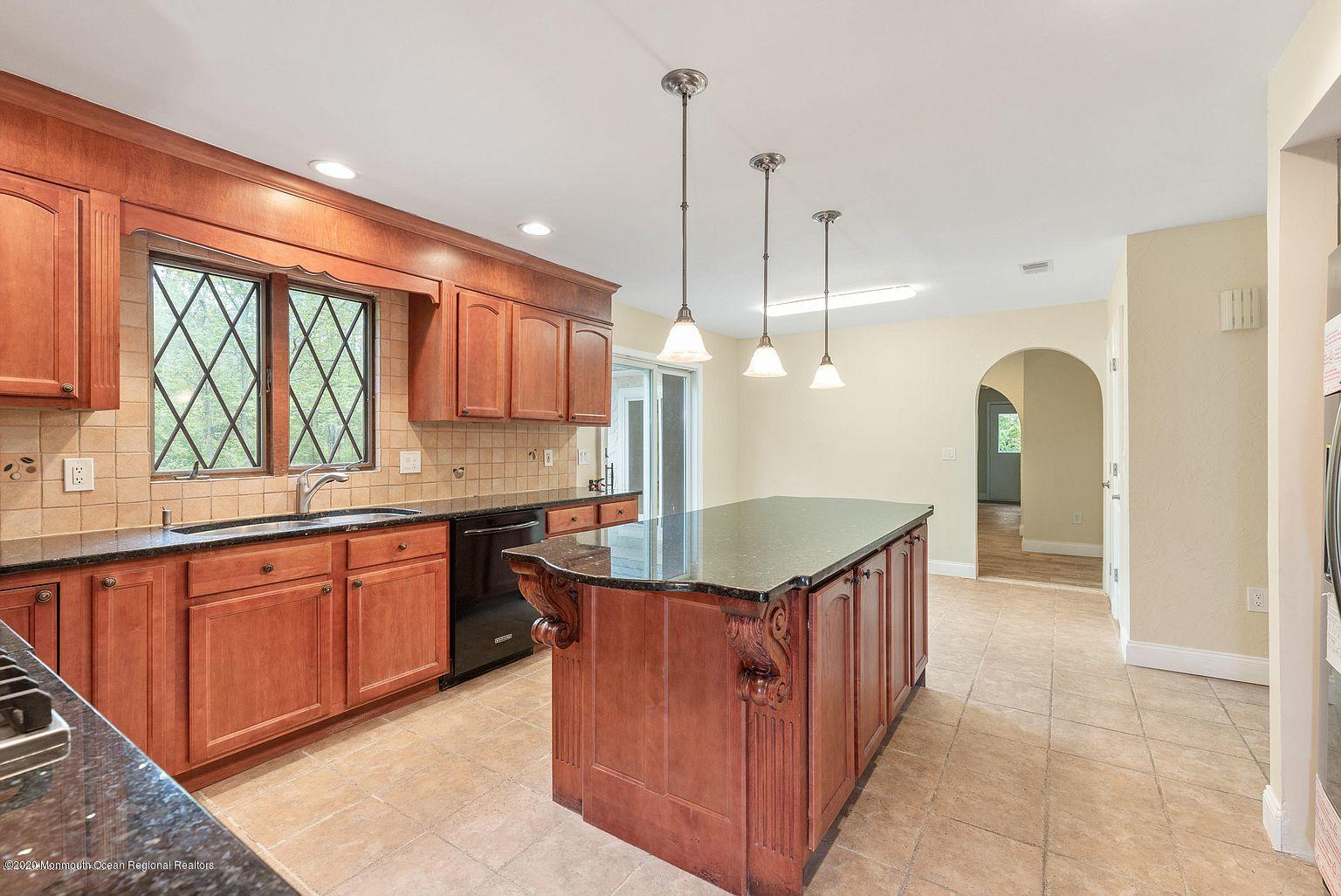 33 Heath Avenue Oakhurst, NJ 07755 - Photo 14 of 48 a kitchen with kitchen island granite countertop a sink a counter top space and stainless steel appliances