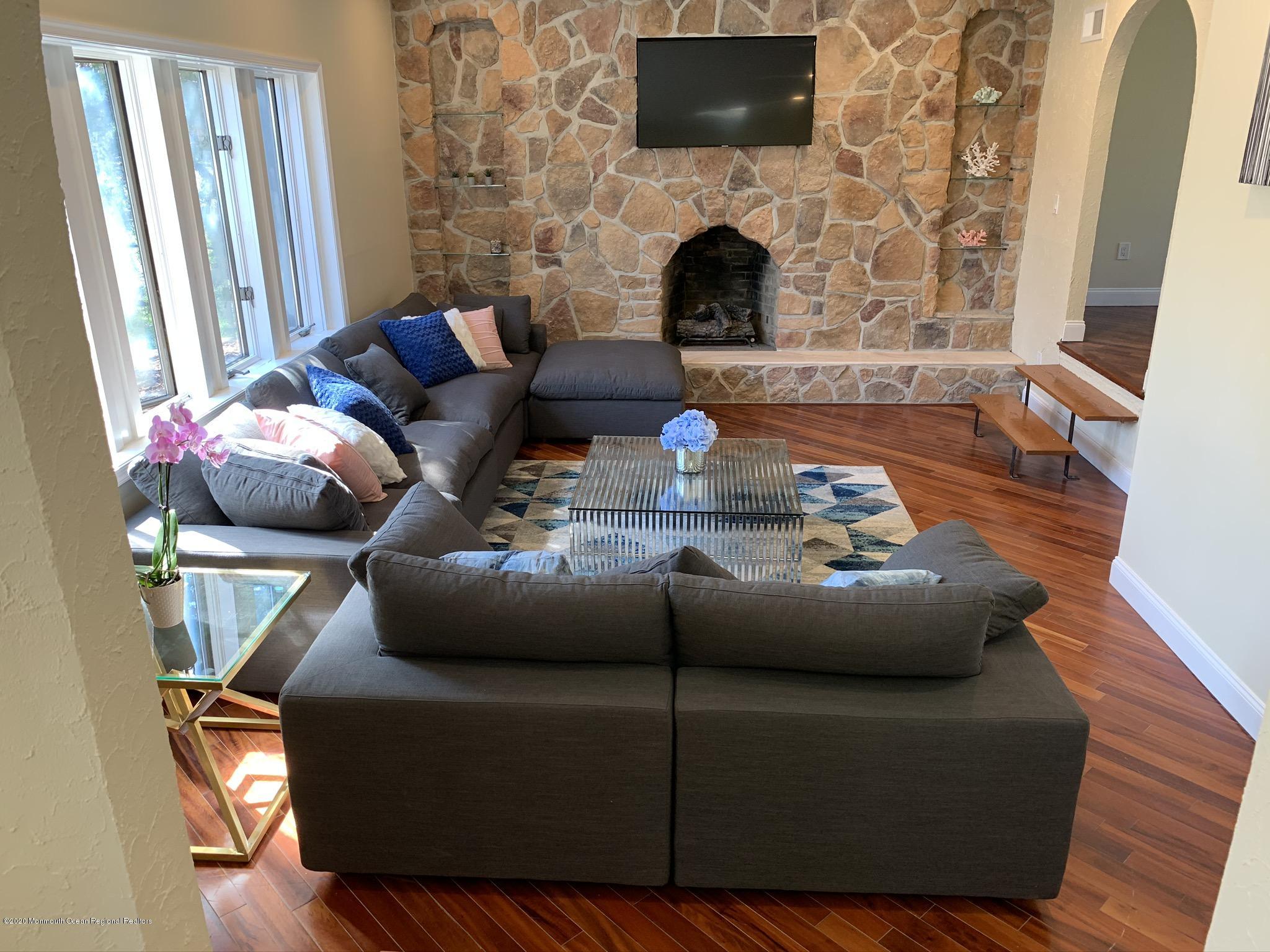 33 Heath Avenue Oakhurst, NJ 07755 - Photo 17 of 48 a living room with furniture a fireplace and a flat screen tv