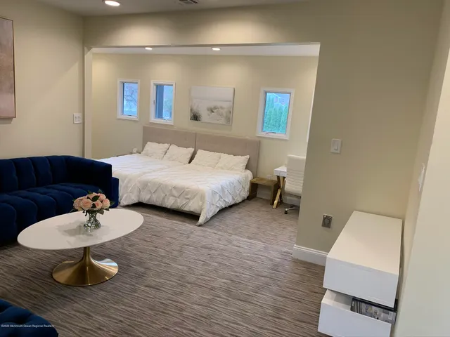 a spacious bathroom with a granite countertop sink a toilet a mirror and shower