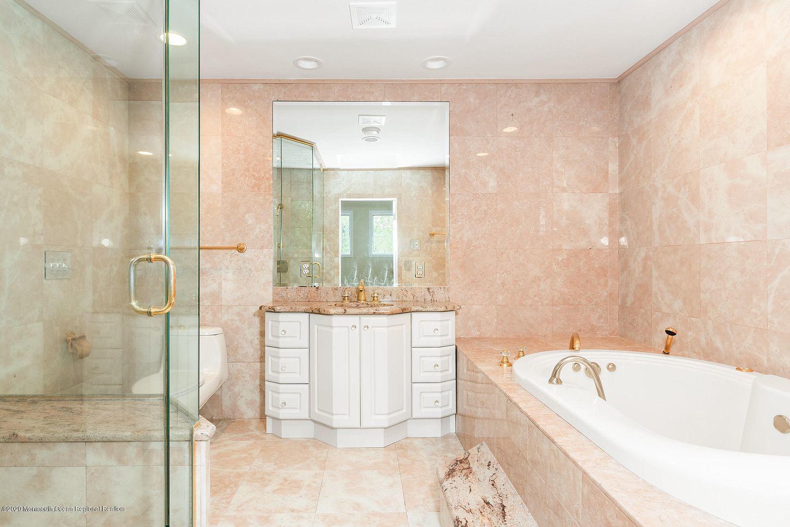 33 Heath Avenue Oakhurst, NJ 07755 - Photo 28 of 48 a bathroom with a bathtub a mirror a vanity and a shower