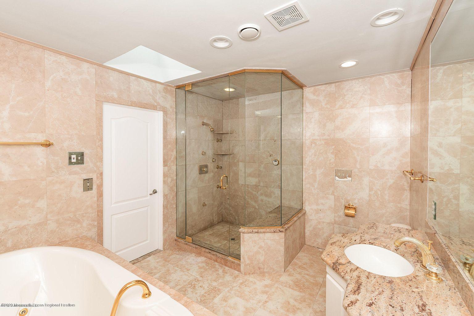 33 Heath Avenue Oakhurst, NJ 07755 - Photo 29 of 48 a spacious bathroom with a granite countertop sink a toilet a mirror and shower