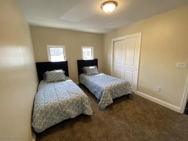 a bedroom with a bed and painting on the wall