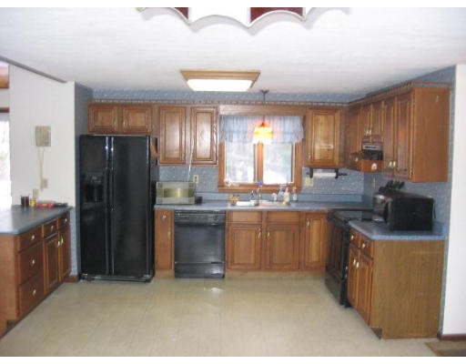 292 Mulpus Road Lunenburg, MA 01462 - Photo 2 of 18 a kitchen with stainless steel appliances granite countertop a refrigerator a sink dishwasher and wooden cabinets