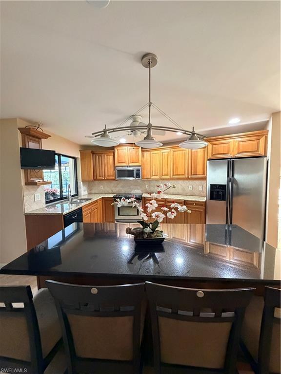 1941 Princess Court Naples, FL 34110 - Photo 10 of 17 a kitchen with a table chairs and flat screen