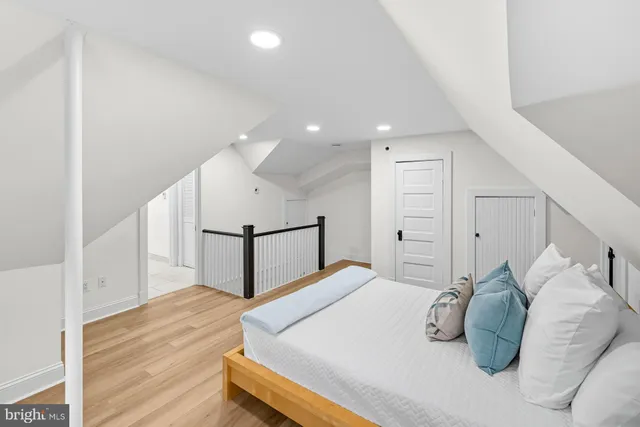 a bedroom with a large bed and wooden floor