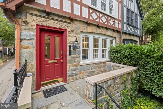 a view of brick building with a red door and a porch