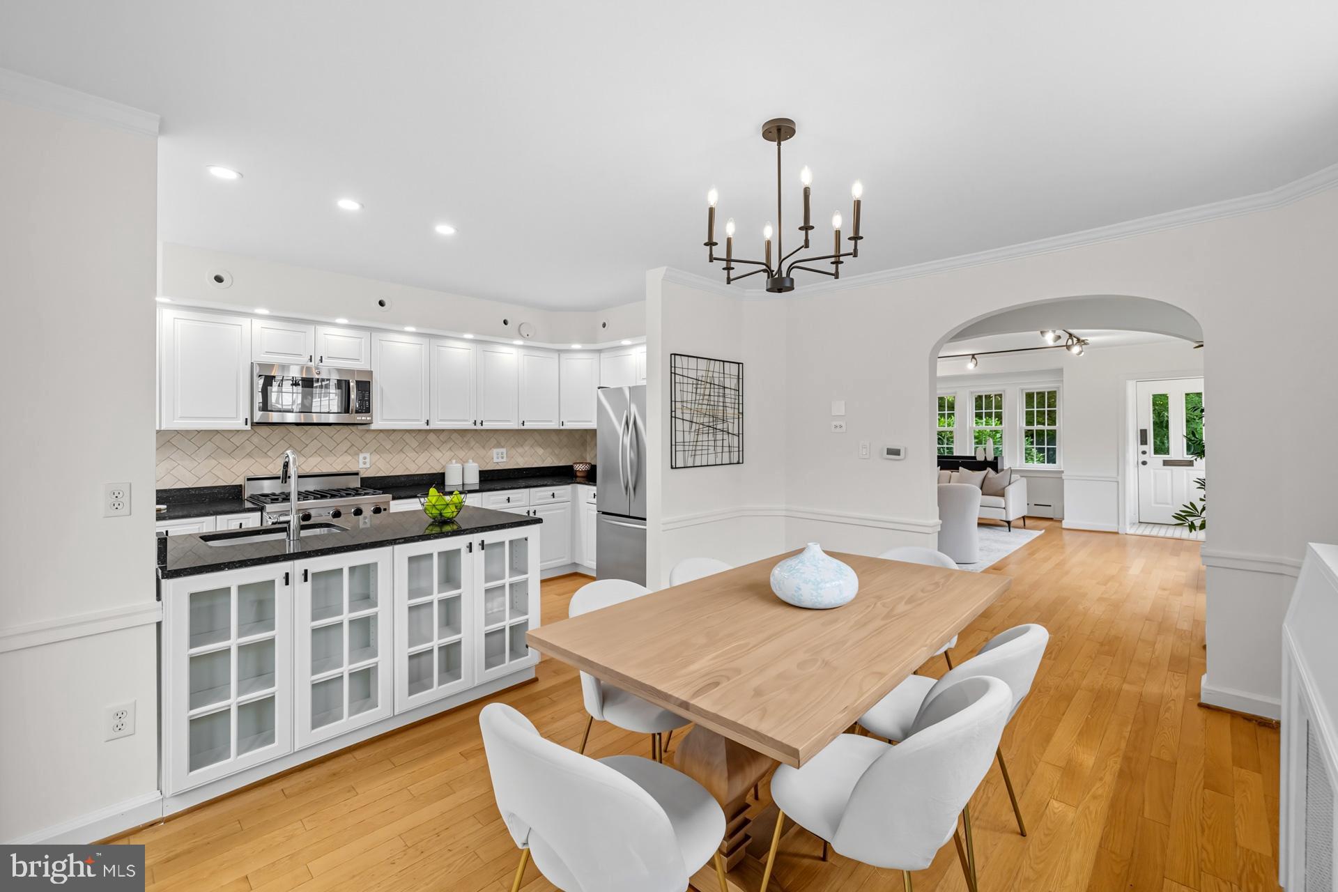 1628 44th Street Northwest Washington, DC 20007 - Photo 8 of 40 a kitchen with stainless steel appliances granite countertop a stove a sink a refrigerator dining table and chairs