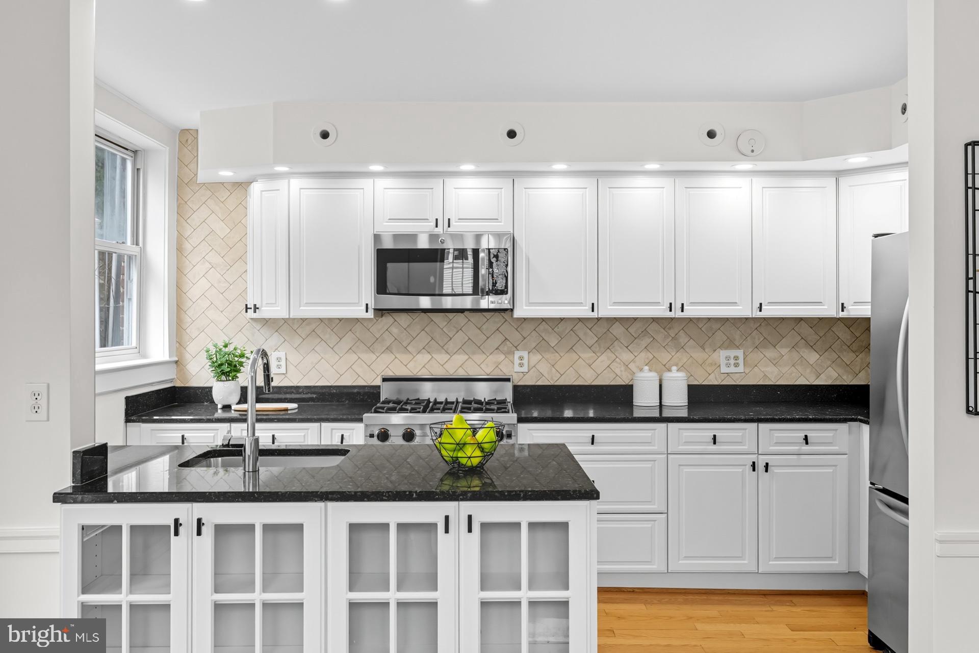 1628 44th Street Northwest Washington, DC 20007 - Photo 10 of 40 a kitchen with stainless steel appliances granite countertop a sink and cabinets