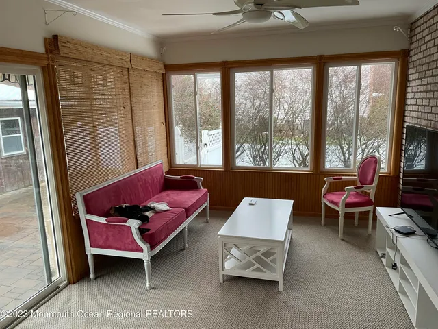 a living room with furniture and a floor to ceiling window