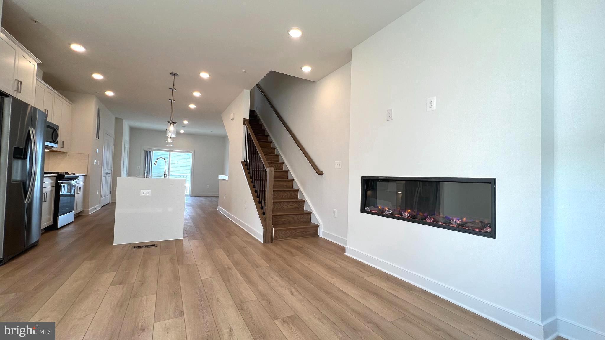 3122 Nina Clarke Drive Gaithersburg, MD 20877 - Photo 14 of 22 a view of a hallway with the kitchen and wooden floor