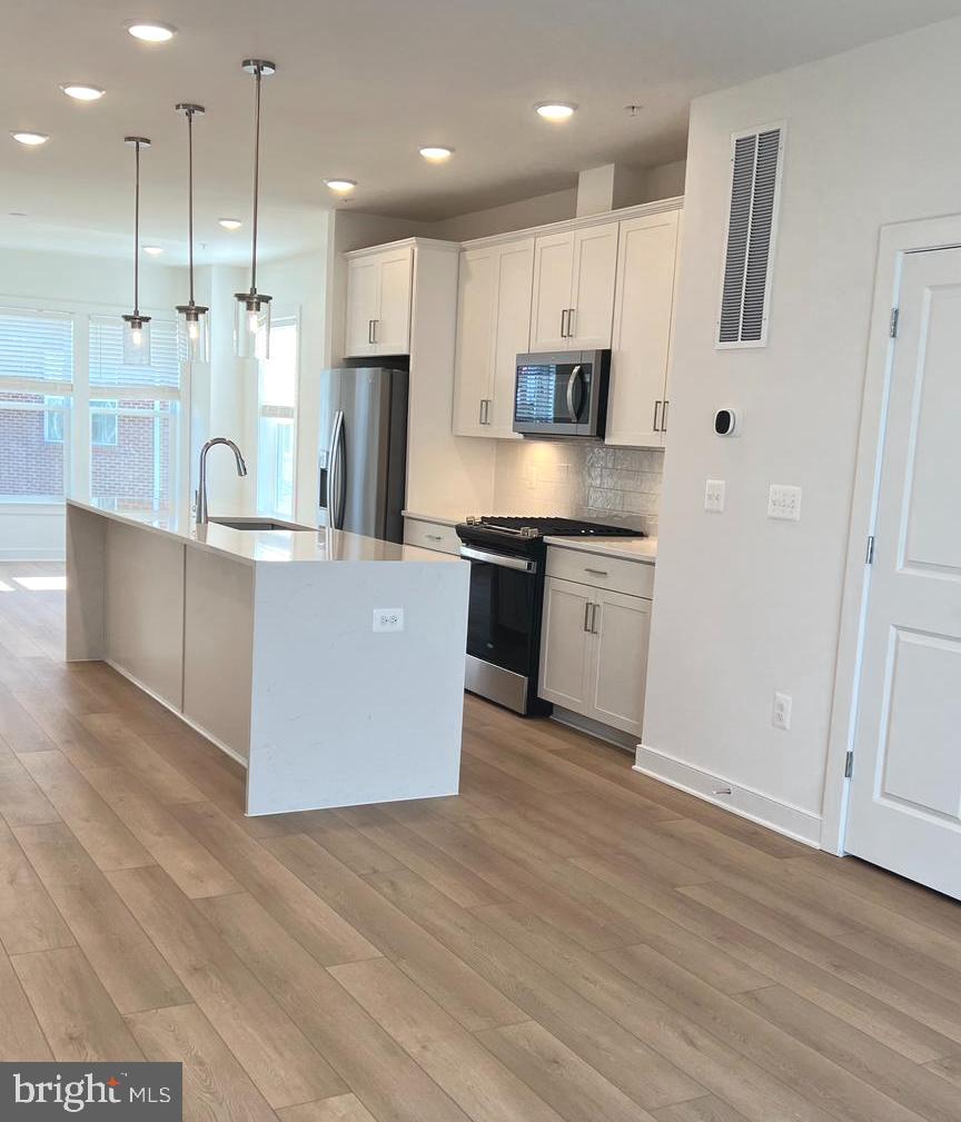 3122 Nina Clarke Drive Gaithersburg, MD 20877 - Photo 5 of 22 a large kitchen with stainless steel appliances granite countertop a large counter top and a stove with wooden floor