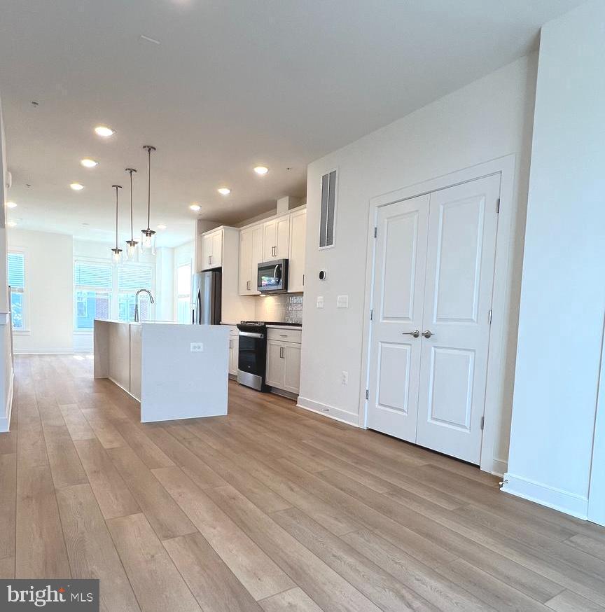 3122 Nina Clarke Drive Gaithersburg, MD 20877 - Photo 9 of 22 a large kitchen with kitchen island a stove a refrigerator a sink dishwasher with a dining table and wooden floor