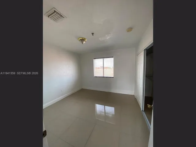 an empty room with windows and closet