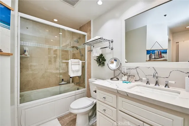 a bathroom with a sink a toilet and a large mirror