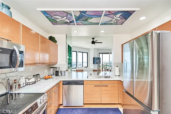 a large kitchen with stainless steel appliances granite countertop a sink and cabinets