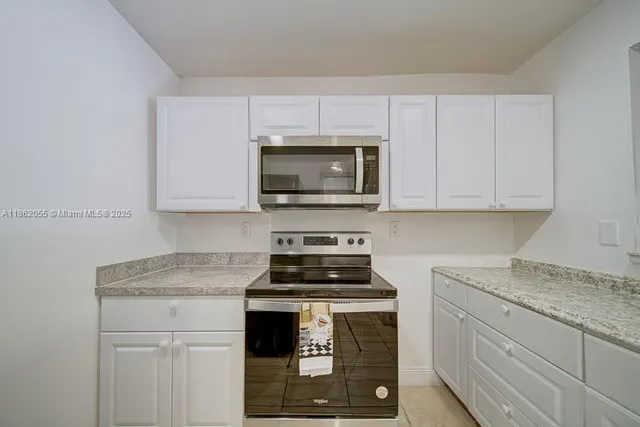 a kitchen with stainless steel appliances granite countertop a sink stove and microwave