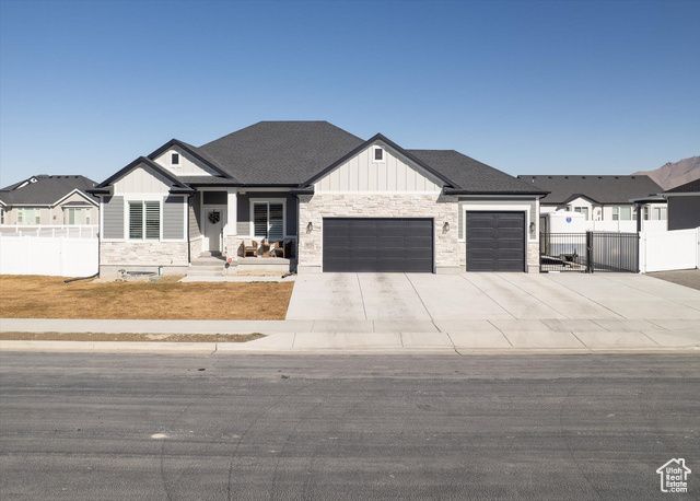 307 East Prestwick Lane, Unit 606 Tooele, UT 84074 - Photo 1 of 1 Modern farmhouse style home with stone siding, a gate, fence, and board and batten siding