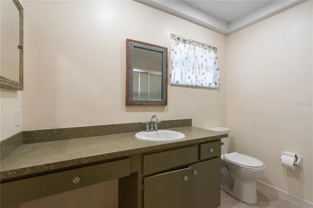 a bathroom with a granite countertop sink mirror and toilet