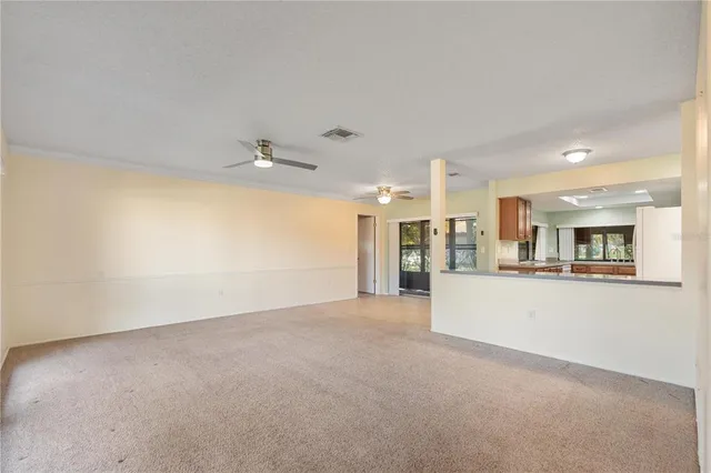a view of an empty room with a kitchen