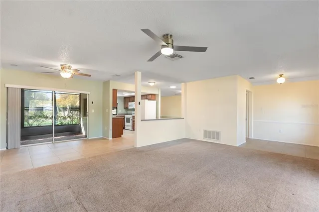 a view of a livingroom with wooden floor and a ceiling fan