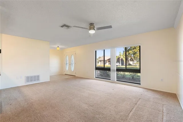 a view of empty room with ceiling fan