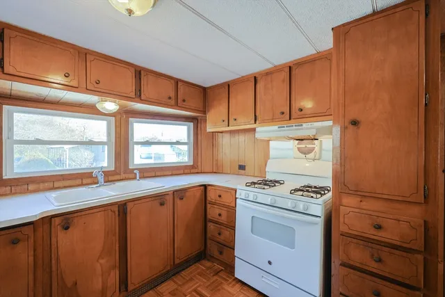 a kitchen with granite countertop cabinets appliances and a window