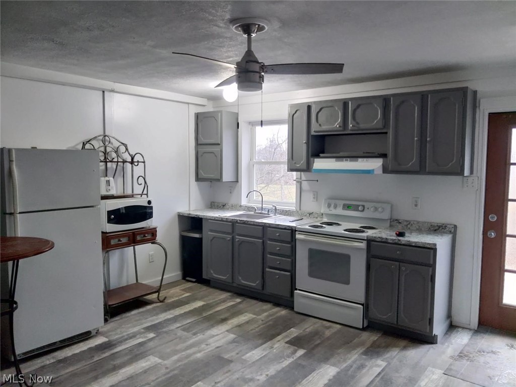 3995 Clay Pike Road Cambridge, OH 43725 - Photo 5 of 10 Kitchen featuring gray cabinets, white appliances, light countertops, ceiling fan, and dark wood-style flooring