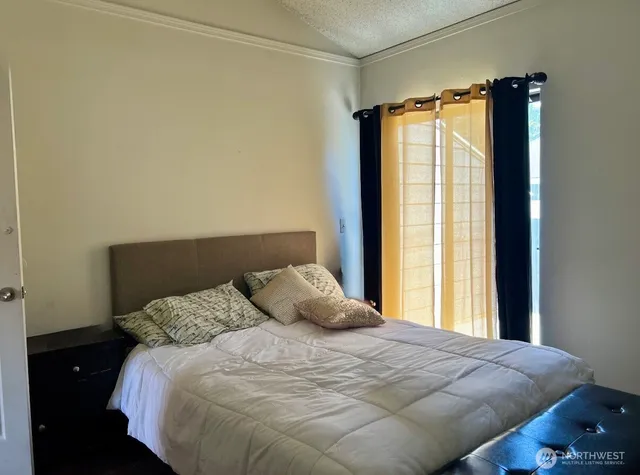 a bedroom with a bed and a window