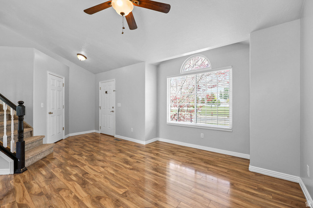 142 East 2675th Street South Clearfield, UT 84015 - Photo 7 of 49 Spacious interior featuring wood-finish flooring, a large window with an arched transom, and a ceiling fan
