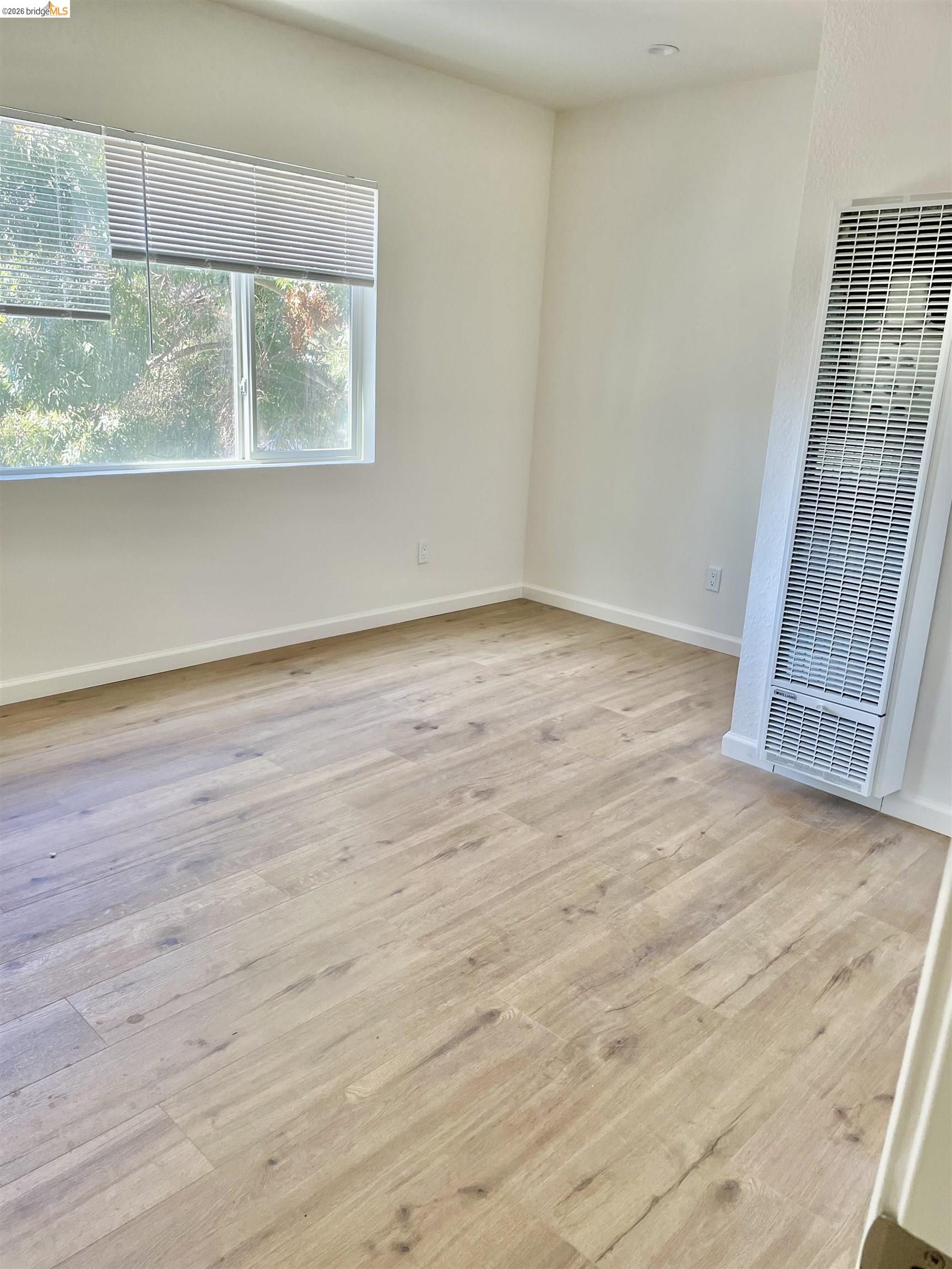 1507 Prince Street Berkeley, CA 94703 - Photo 15 of 30 a view of an empty room with wooden floor and a window