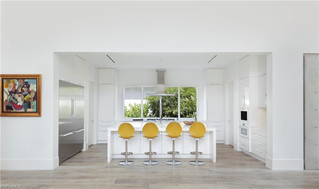 387 Bow Line Drive Naples, FL 34103 - Photo 9 of 18 a view of dining hall with wooden floor and sofas