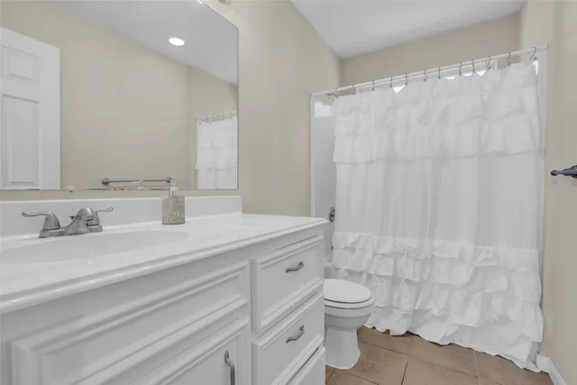 a bathroom with a granite countertop sink a toilet and a shower