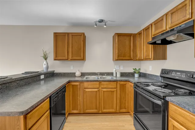 a kitchen with stainless steel appliances granite countertop a sink stove and cabinets