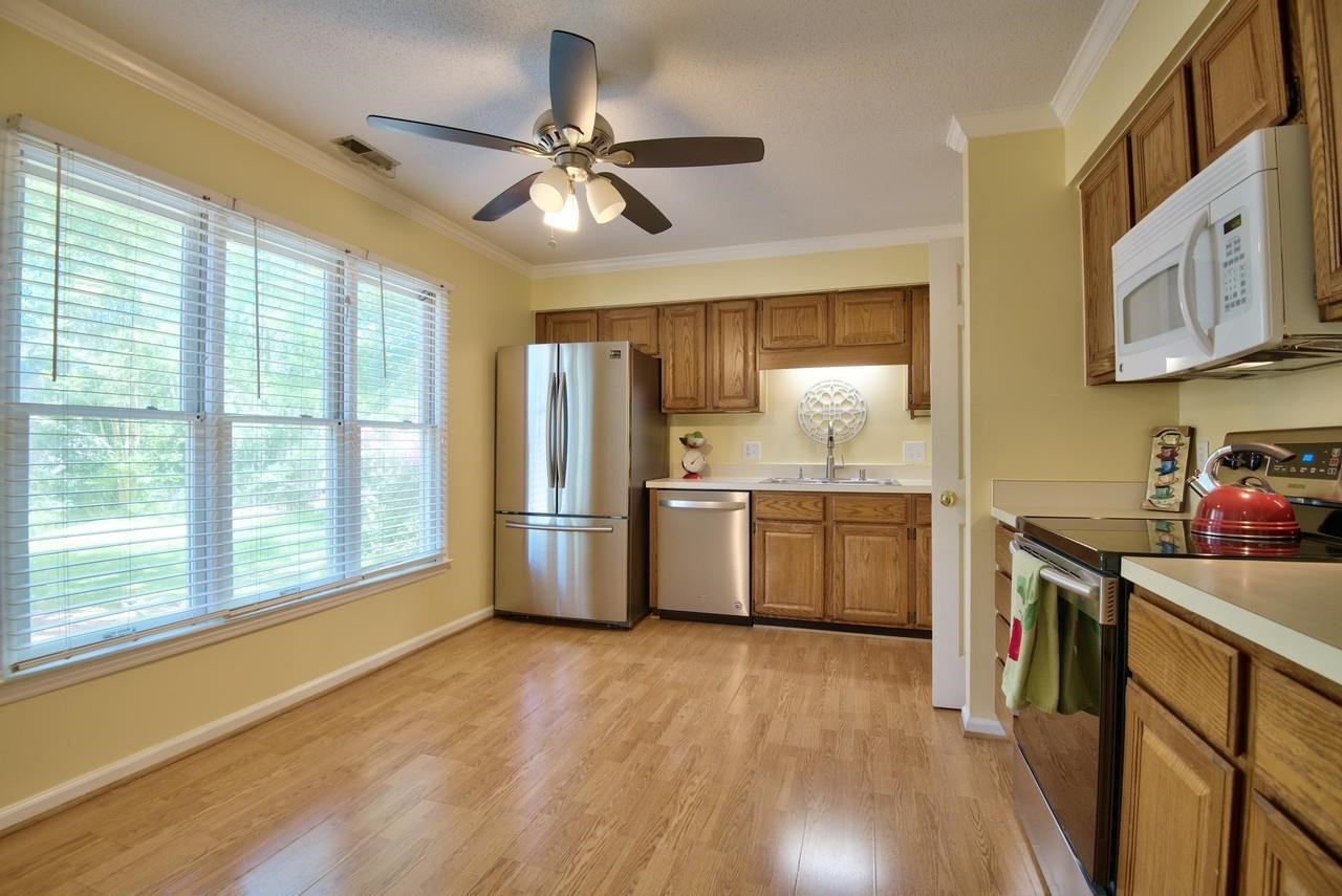 3219 Coachman's Way Durham, NC 27705 - Photo 10 of 33 a kitchen with stainless steel appliances a sink cabinets and wooden floor