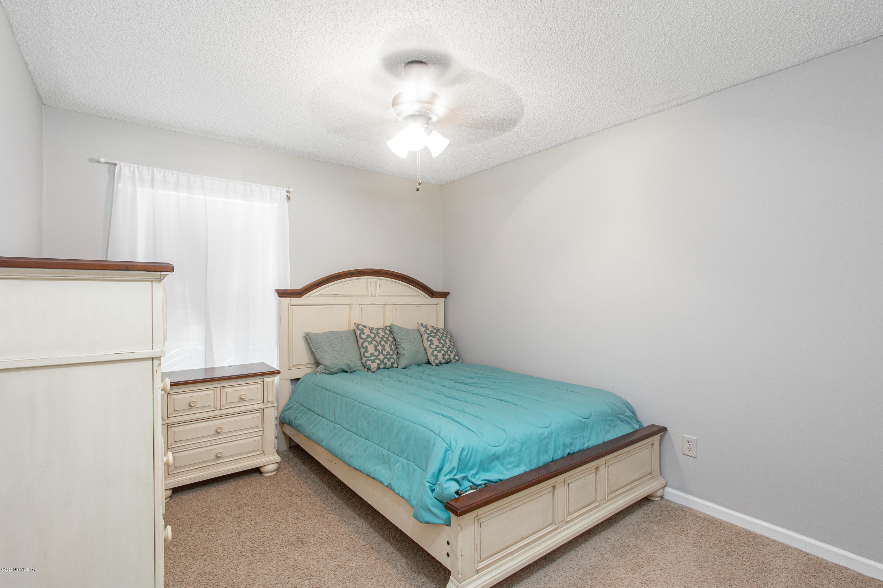 1214 Raleigh Ridge Drive Jacksonville, FL 32225 - Photo 13 of 25 a bedroom with a bed and a chandelier