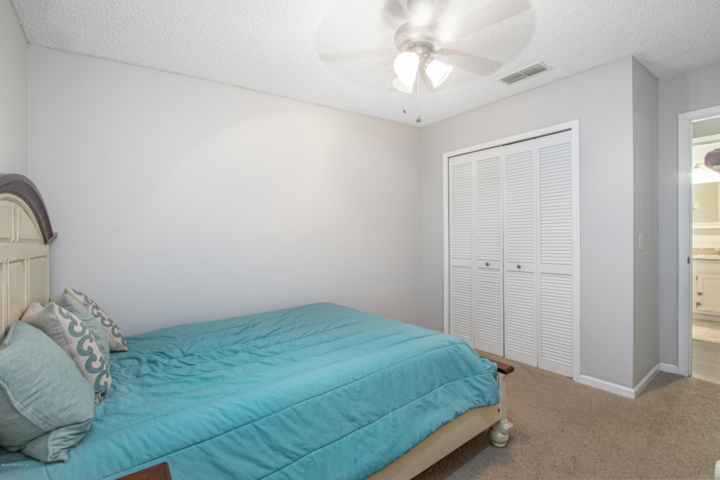 1214 Raleigh Ridge Drive Jacksonville, FL 32225 - Photo 14 of 25 a bedroom with a bed and a chandelier
