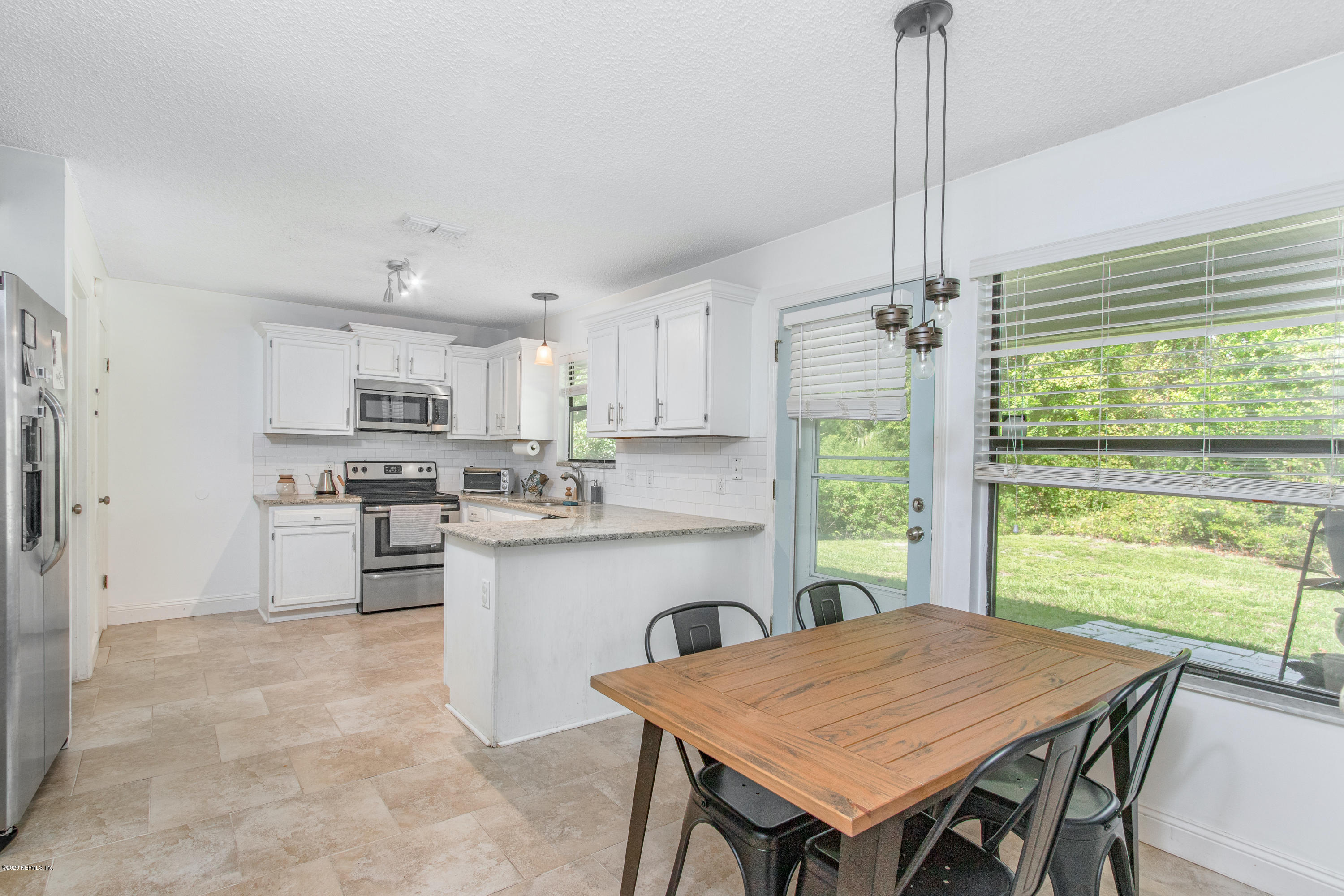 1214 Raleigh Ridge Drive Jacksonville, FL 32225 - Photo 5 of 25 a kitchen with a table chairs stove and refrigerator