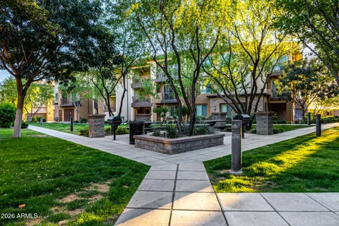 a front view of a house with garden and trees