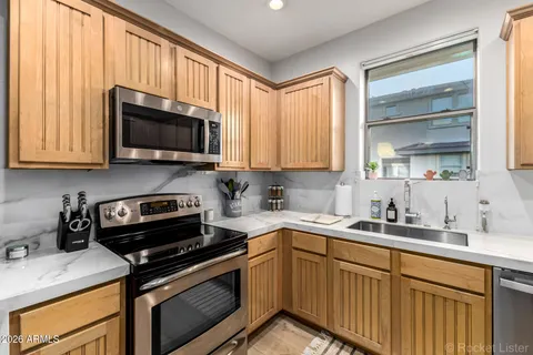 a kitchen with a sink a stove and cabinets