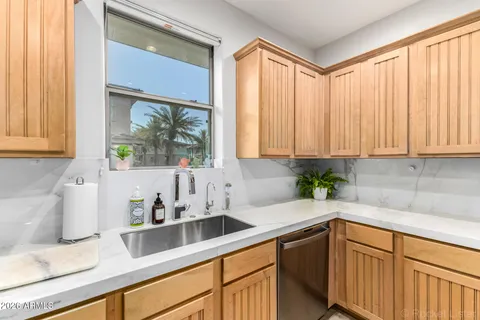 a kitchen with stainless steel appliances white cabinets a window and a sink