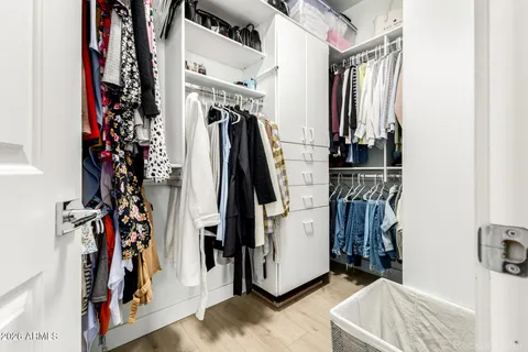 a view of walk in closet with clothes and shoes