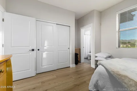 a bedroom with a bed and wooden floor